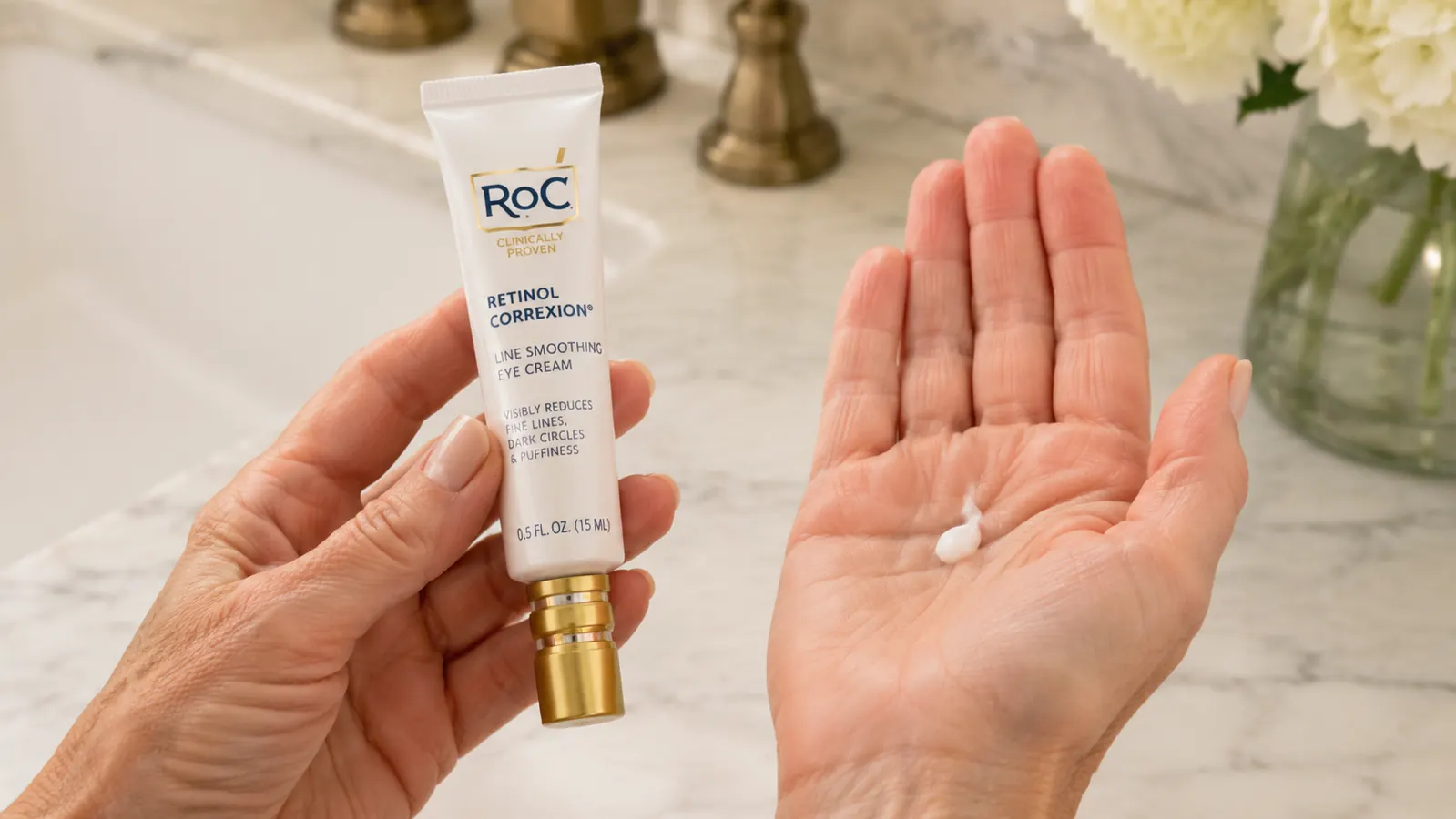 Hand holding the small RoC Retinol Correxion Under Eye Cream tube next to an open palm showing a rice-grain-sized amount of cream